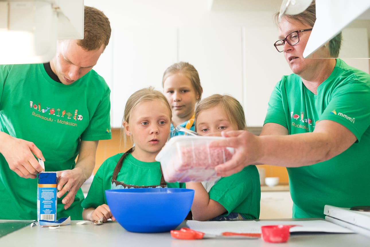 Ruokakoululaiset Venla Heikkinen, MIlla Kukka ja Emilia Kurtti alkamassa lihapullataikinan tekoon. Opastamassa Kuusamon 4H:n toiminnanjohtaja Taina Pitkänen sekä ohjaaja Anssi Järvinen.