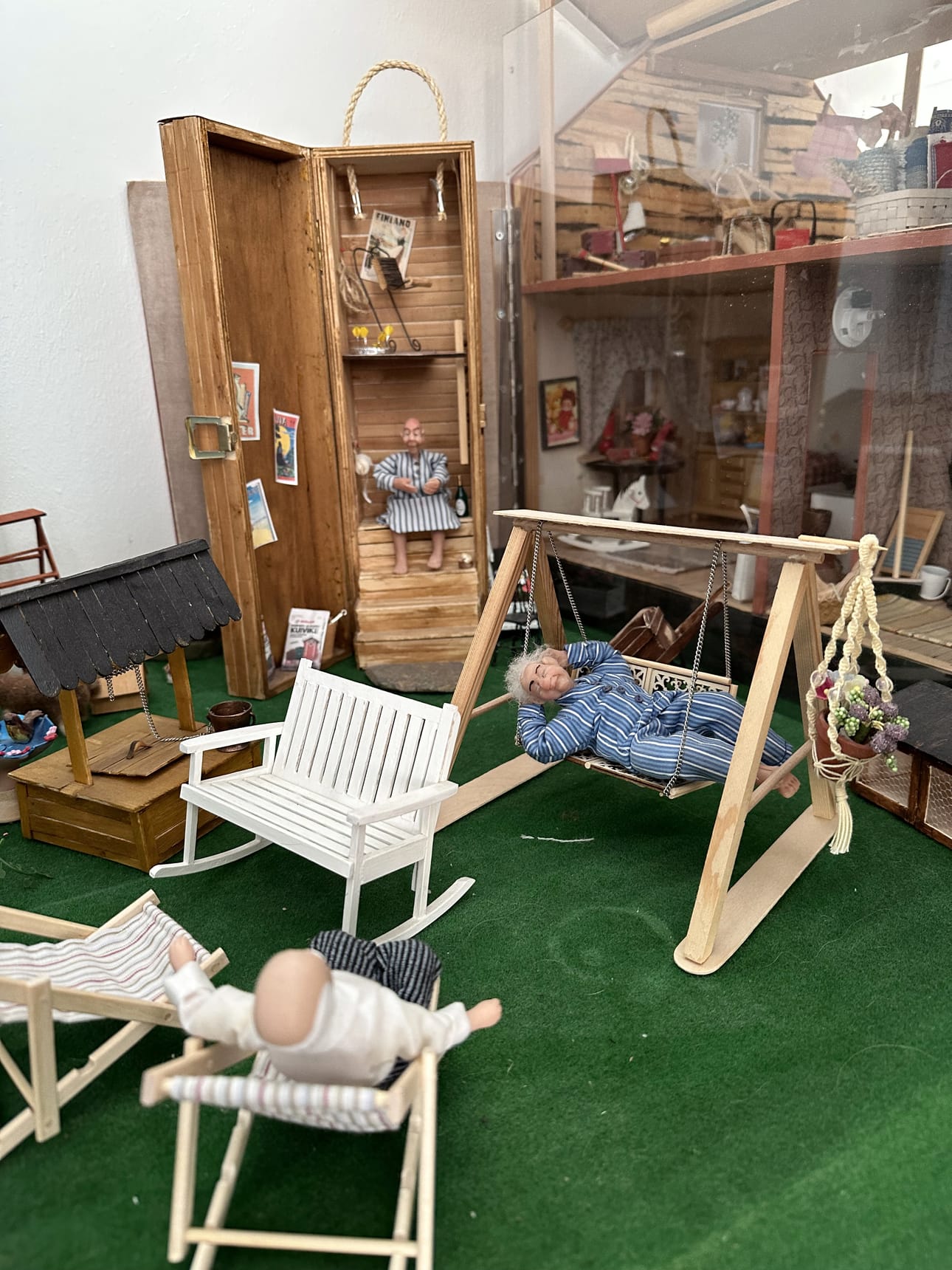 Talojen välillä on puutarha. Ulkovessan Aila Latva-Karjanmaa on rakentanut viinipullon laatikosta.