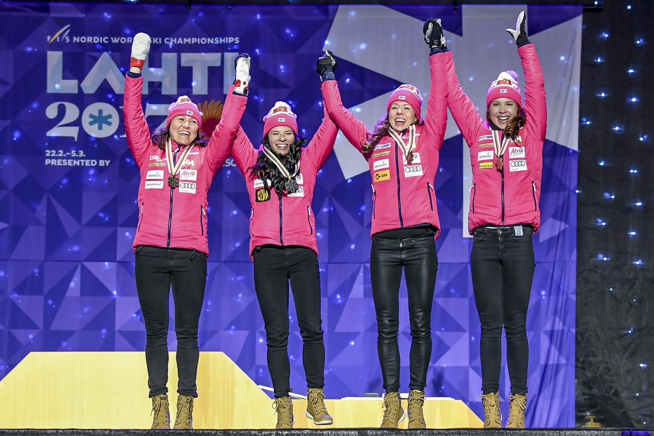 Pronssijoukkueessa hiihtivät Aino-Kaisa Saarinen (vas.), Krista Pärmäkoski, Laura Mononen ja Kerttu Niskanen. Nelikko hyppi tasajalkaa noustessaan palkintokorokkeelle.