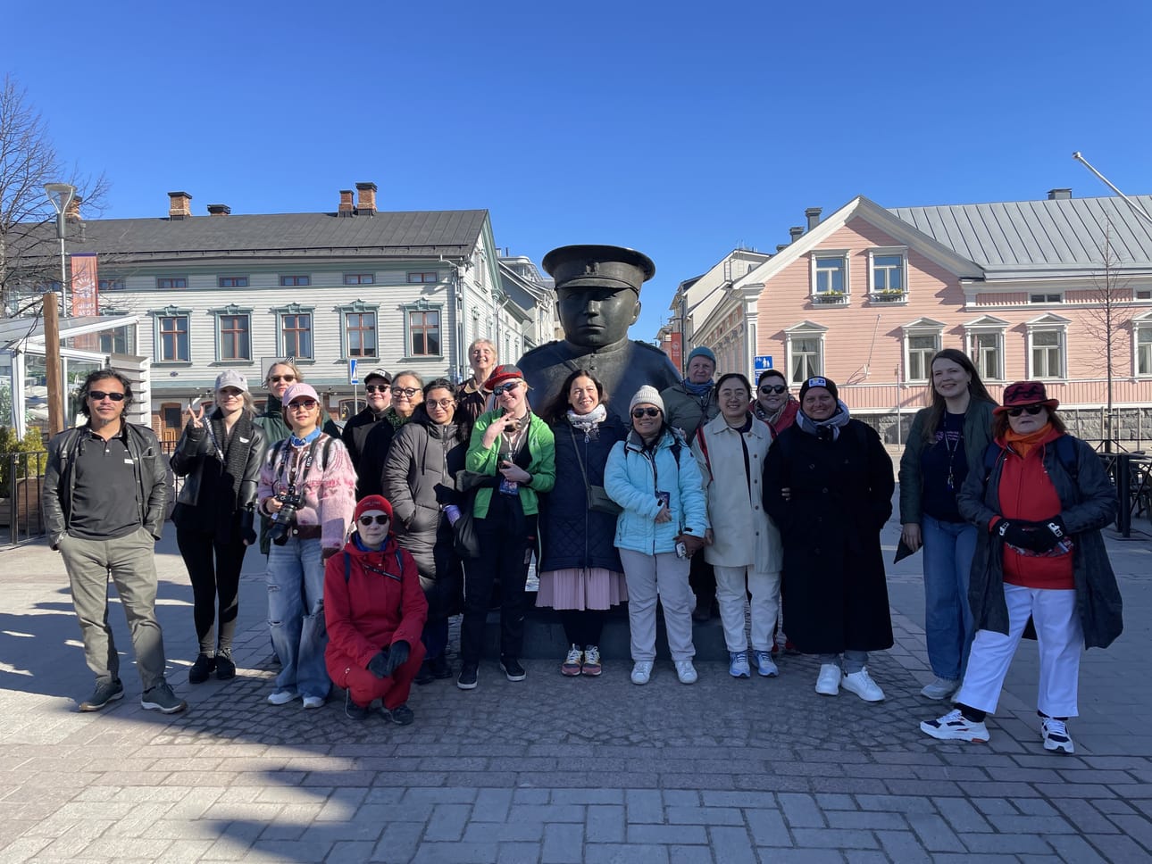 Ryhmä Toripolliisi-patsaan edustalla kaupunkikierroksella.