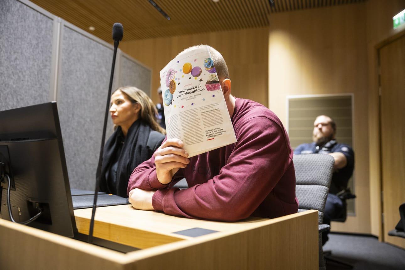Mies peitti kasvonsa, kun oikeus antoi kuvausluvan istunnon aluksi.