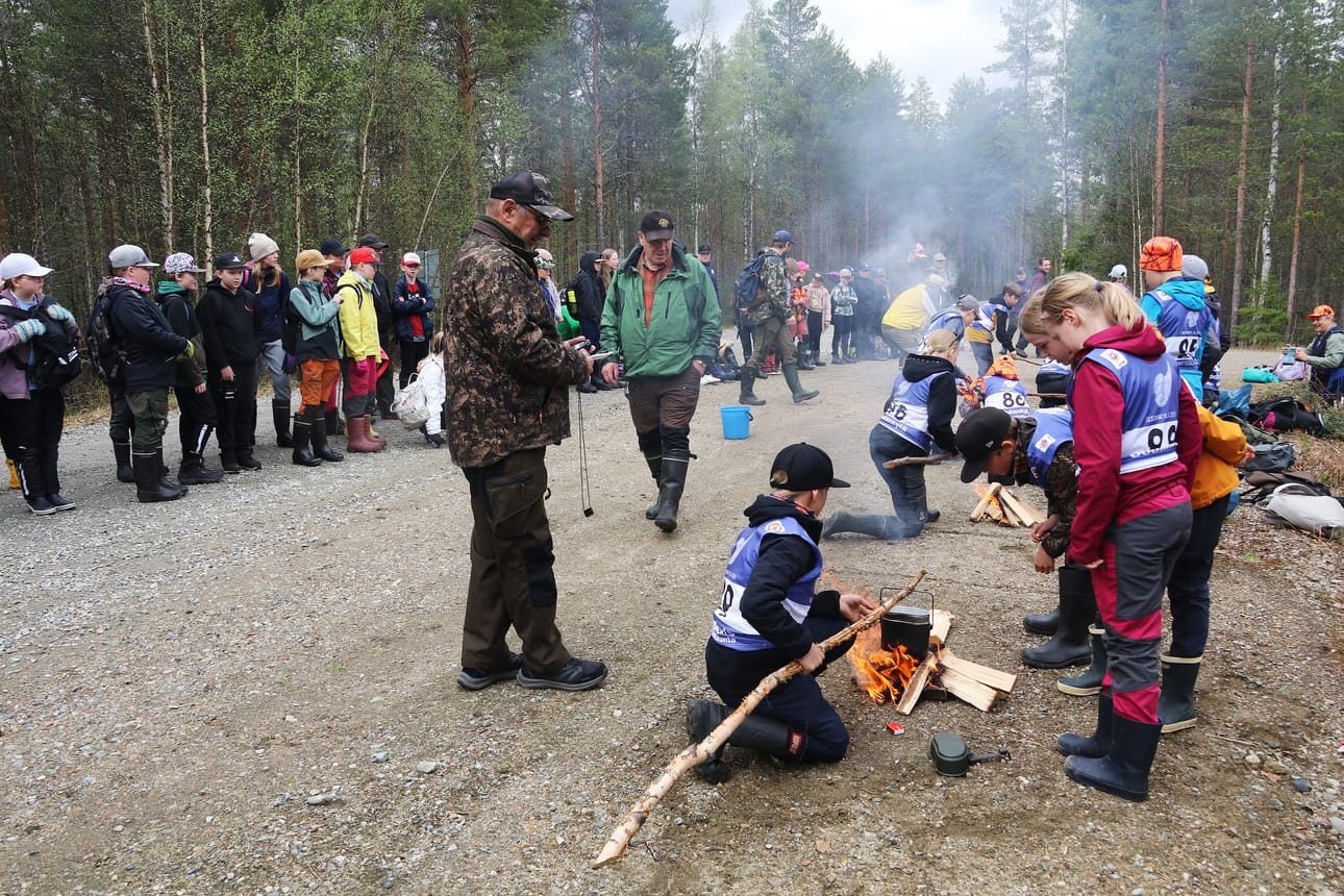 Tulentekokisa käynnissä. Viisi joukkuetta kisasi siitä, kuka sai nopeimmin veden kiehumaan pakissa. Yleisö seurasi ja kannusti.