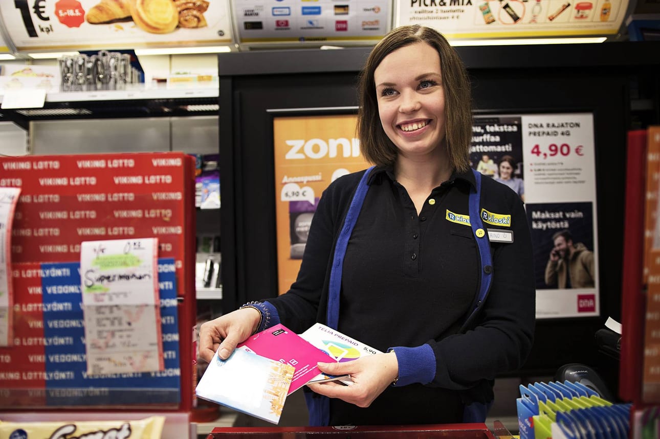 Kioskilla. Aino Korhonen Koskikatu 9:n R-kioskilta joutuu usein selvittelemään minkälaista prepaid-liittymää matkailija tarvitsee – vaihtoehtoja on useita ja englanninkieliset ohjeet löytyvät vasta paketin sisältä. Juuri prepaid-liittymät ja lähdevesi ovat kioskituotteita, joita matkailijat ostavat paljon.