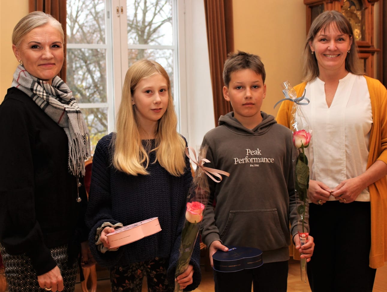 Lasten itsenäisyyspäivän juhlaan Helsinkiin lähtevät Kristiinasta Emilia Wahlroos, Lapväärtistä, ja Joel Haapala, Kantakaupungin Itäpuolelta. Mila Segervall (oik.) ja Maarit Söderlund palkitsivat lapset ruusuin ja suklaarasioin.