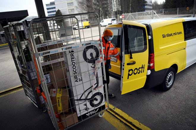 Postin työntekijä pakkasi paketteja kuljetusta varten Helsingissä 14. joulukuuta 2020. KUVA: LEHTIKUVA / ANTTI AIMO-KOIVISTO