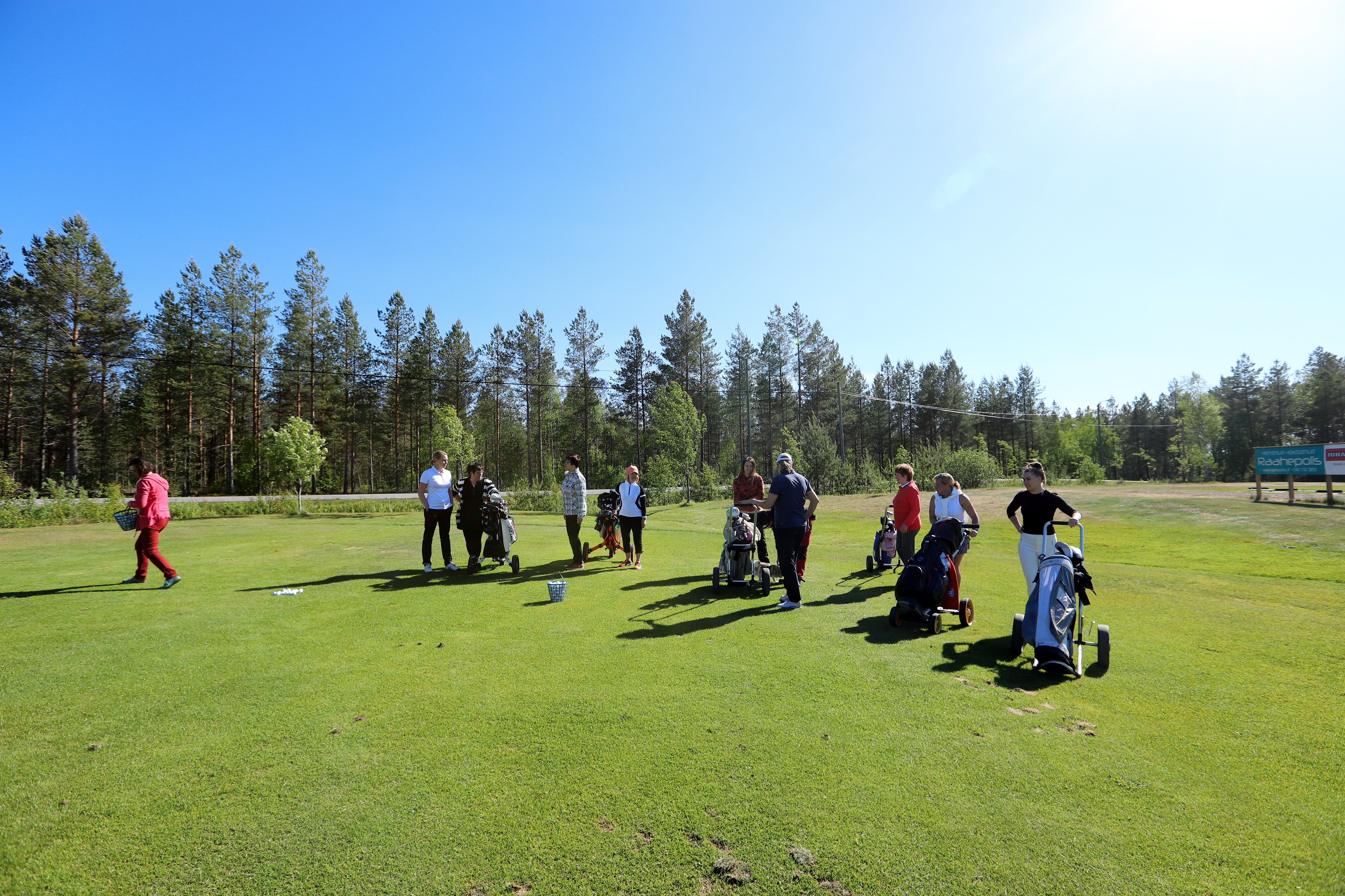 Ennen itse pelien alkua on vuorossa lyöntiharjoituksia myöhempää golfkierrosta silmälläpitäen. Pidempään golfanneet pääsevät koukuttamaan uusia mahdollisia harrastajia lajin pariin.