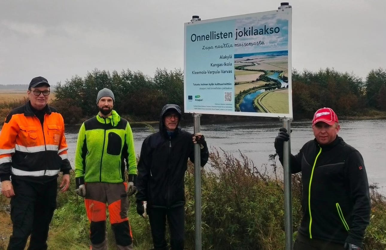 Martti Talkkari, Teemu Passi, Antti Keskikangas ja Pasi Ojanperä urakoivat opaskyltin pystyyn alkuviikosta vesisadetta uhmaten.