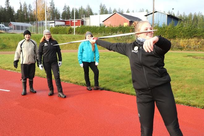 Saga Kurunmäki harjoittelee keihäänheittoa Rannankylän kentällä. Taustalla Tapani Savela, Tuula Kurunmäki ja Silja Kurunmäki.