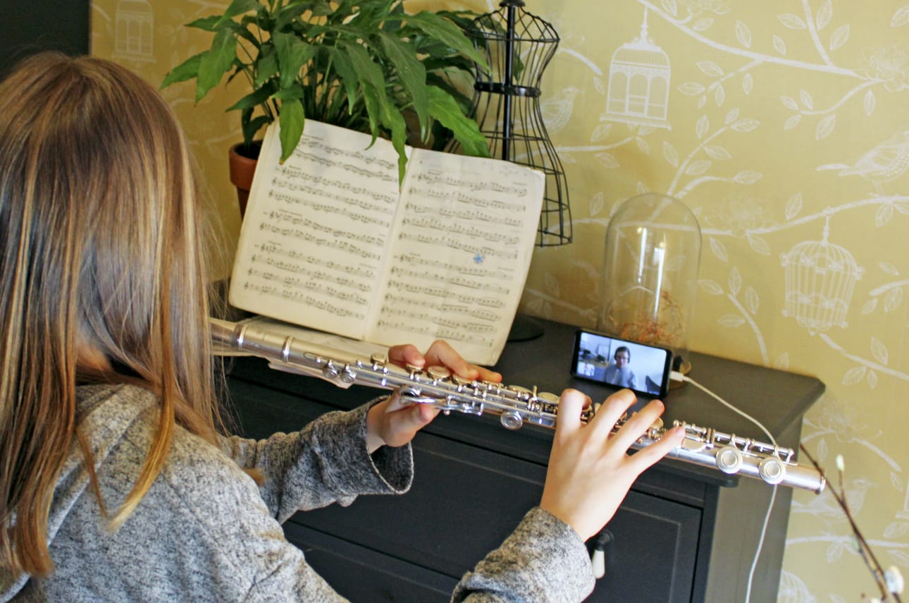 Iiris Kinnunen soittaa huilua Limingan seudun musiikkiopiston opettajan Pekka Elsilän seuratessa etänä. Poikkeustilasta huolimatta musiikkiopistossa on saatu vietyä opetusta eteenpäin mallikkaasti.
