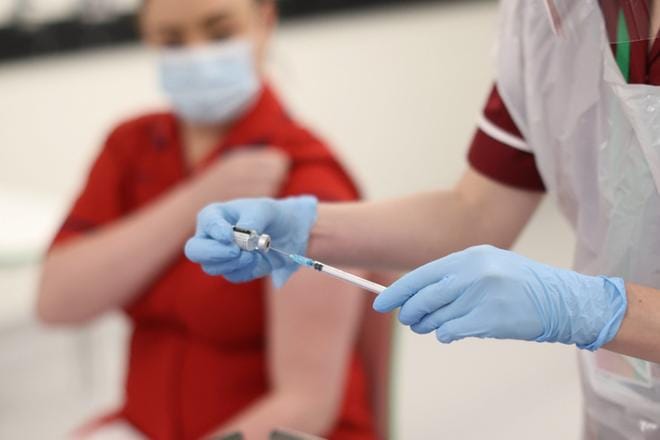 Britanniassa aloitettiin jo koronarokotukset. Listan kärkipäässä ovat terveydenhuollon työntekijät ja yli 80-vuotiaat. Pohjois-Irlannissa ensimmäisen rokotteen sai Joanna Sloan (vas.) KUVA: Liam McBurney/EPA