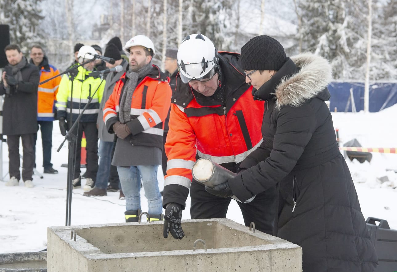 Kirkkoherra Eija Nivala laski aikakapselin muurattavaksi peruskiven sisään .