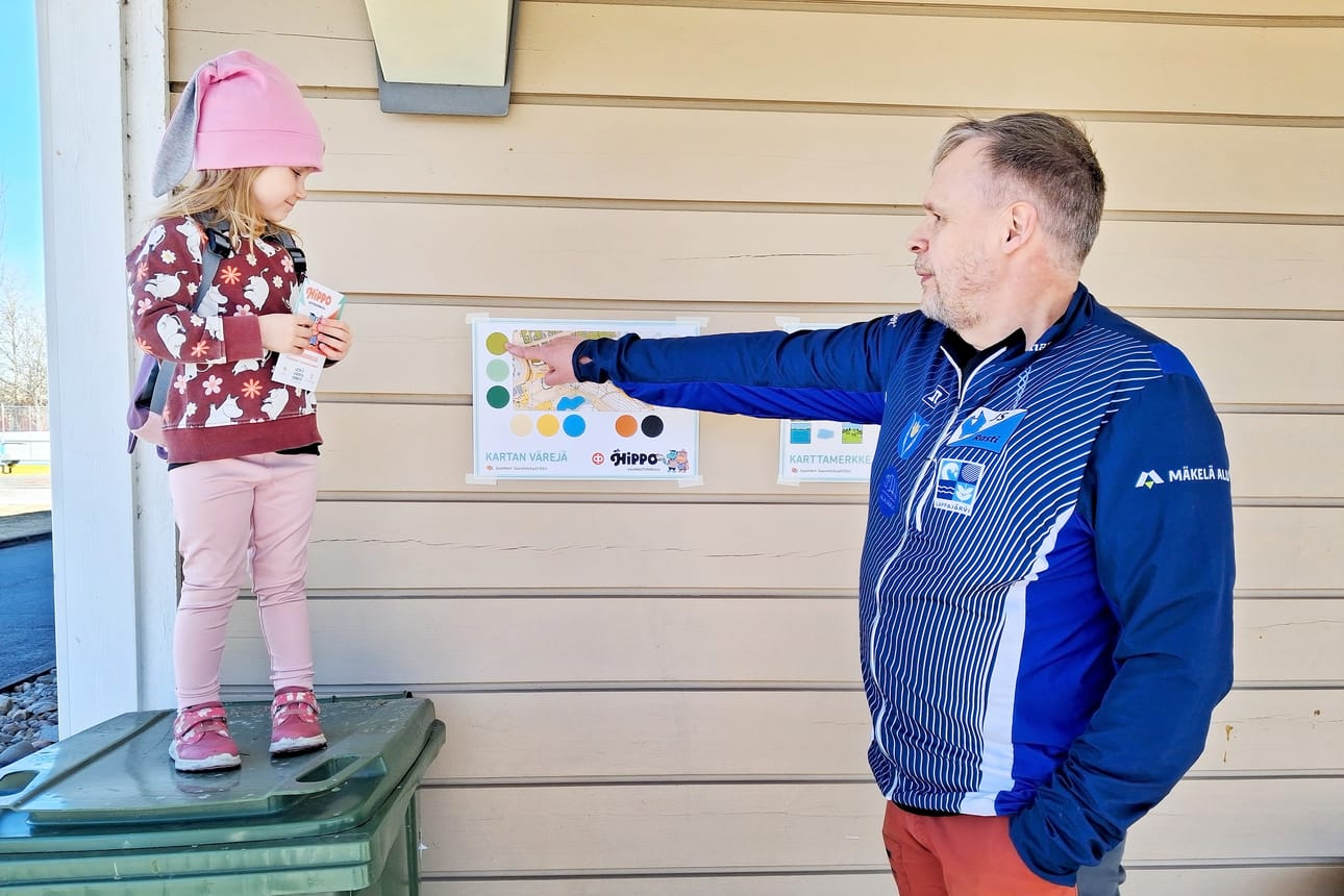 Aada Katajisto, 3, seuraa tarkasti kun Harri Ketola opettaa karttamerkintöjen saloja.