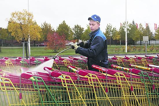 ISS Palveluiden konemies Tomi Hannula puhdistaa ostoskärryjä painepesurilla Limingantullin Prisman pihalla. Kaikki 1 600 ostoskärryä pestään pari kertaa vuodessa.