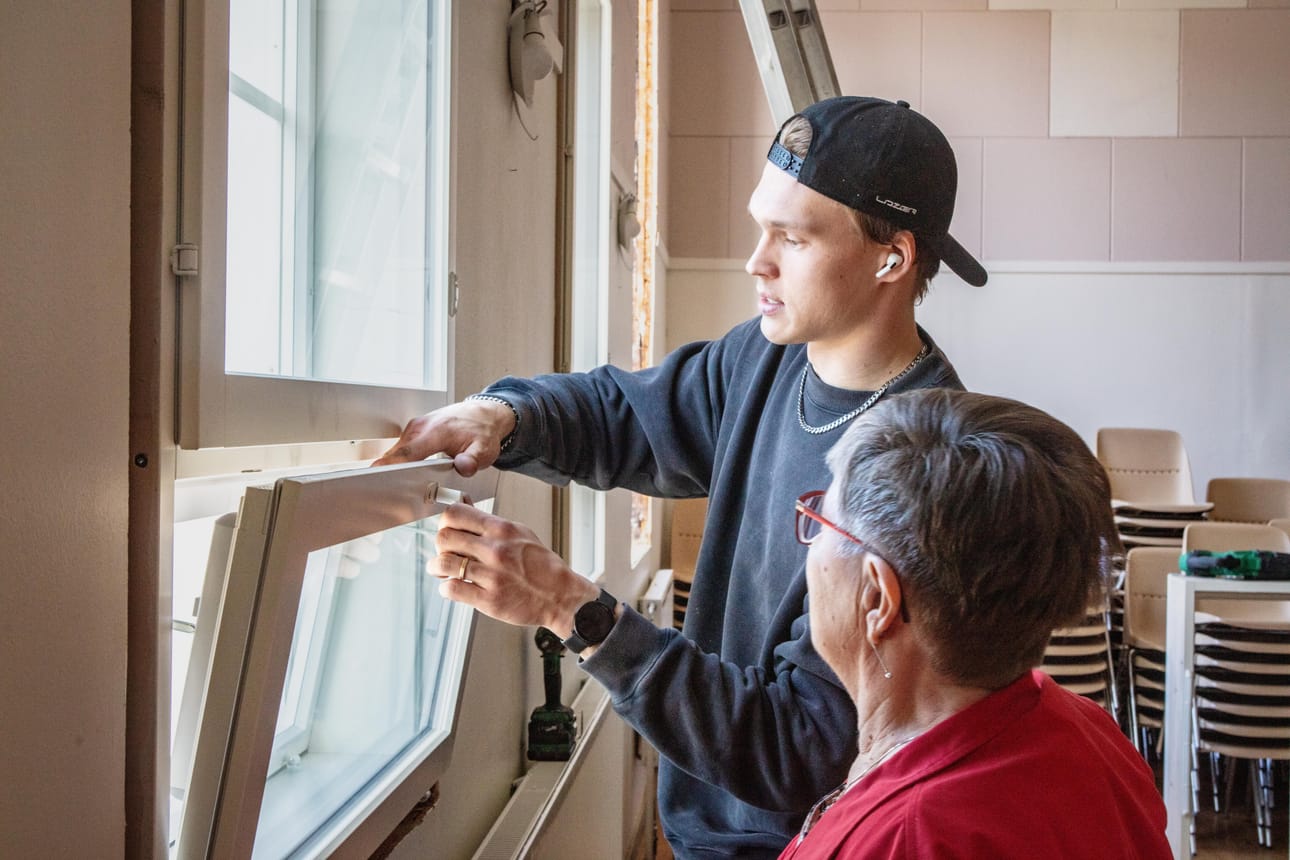 Miika Latvakoski opastaa Aili Virtalaa uusien ikkunoiden käyttöön.