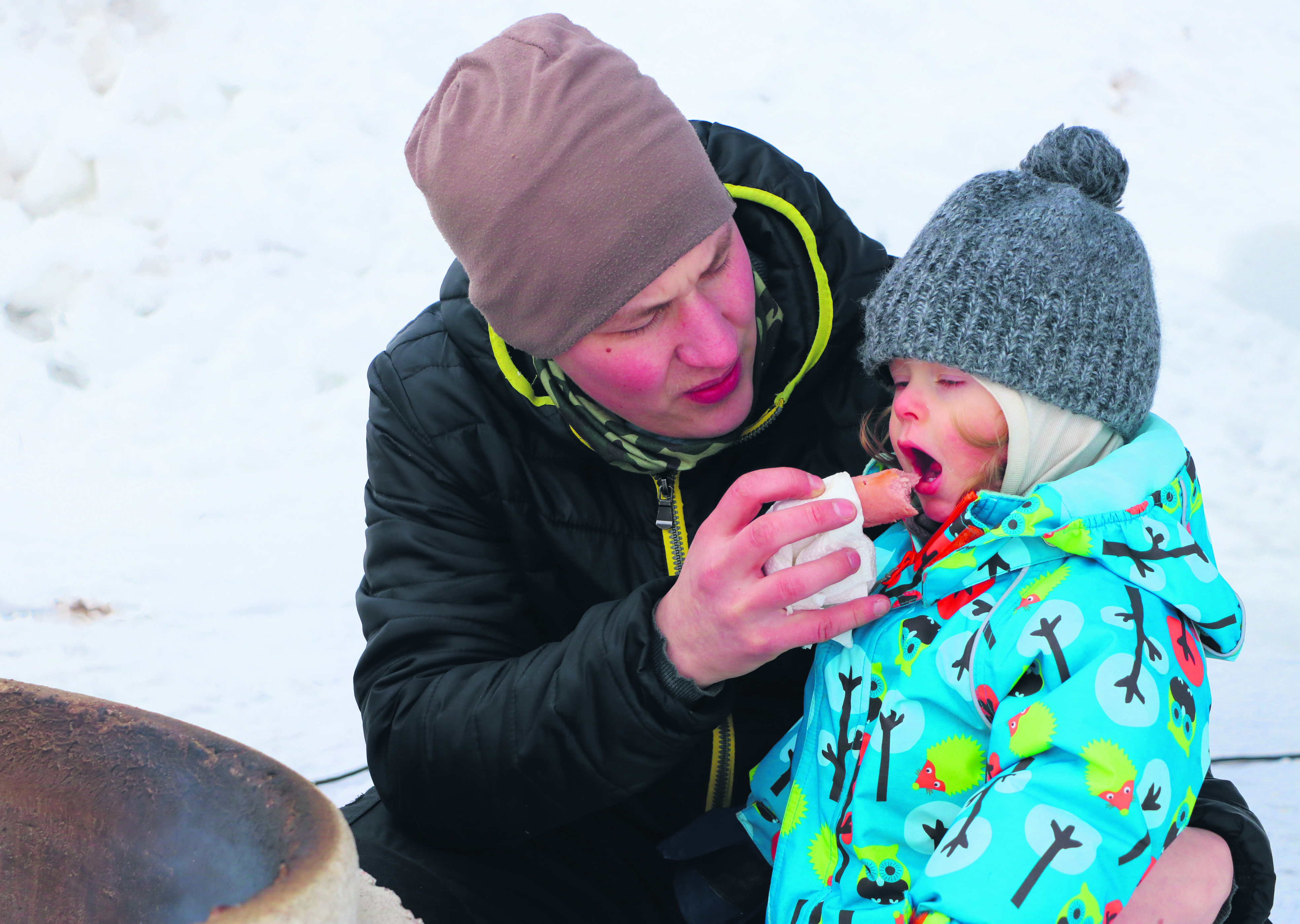 Antti ja Mino (1 vuosi ja 11 kuukautta) Kokko kyykkivät paistamassa makkaraa.  –¿Pitää poika opettaa työn tekoon, nauraa Antti Kokko, jonka yritys Luodon liha ja kala on tullut talvitapahtumaan myymään loimulohta ja säilykkeitä.