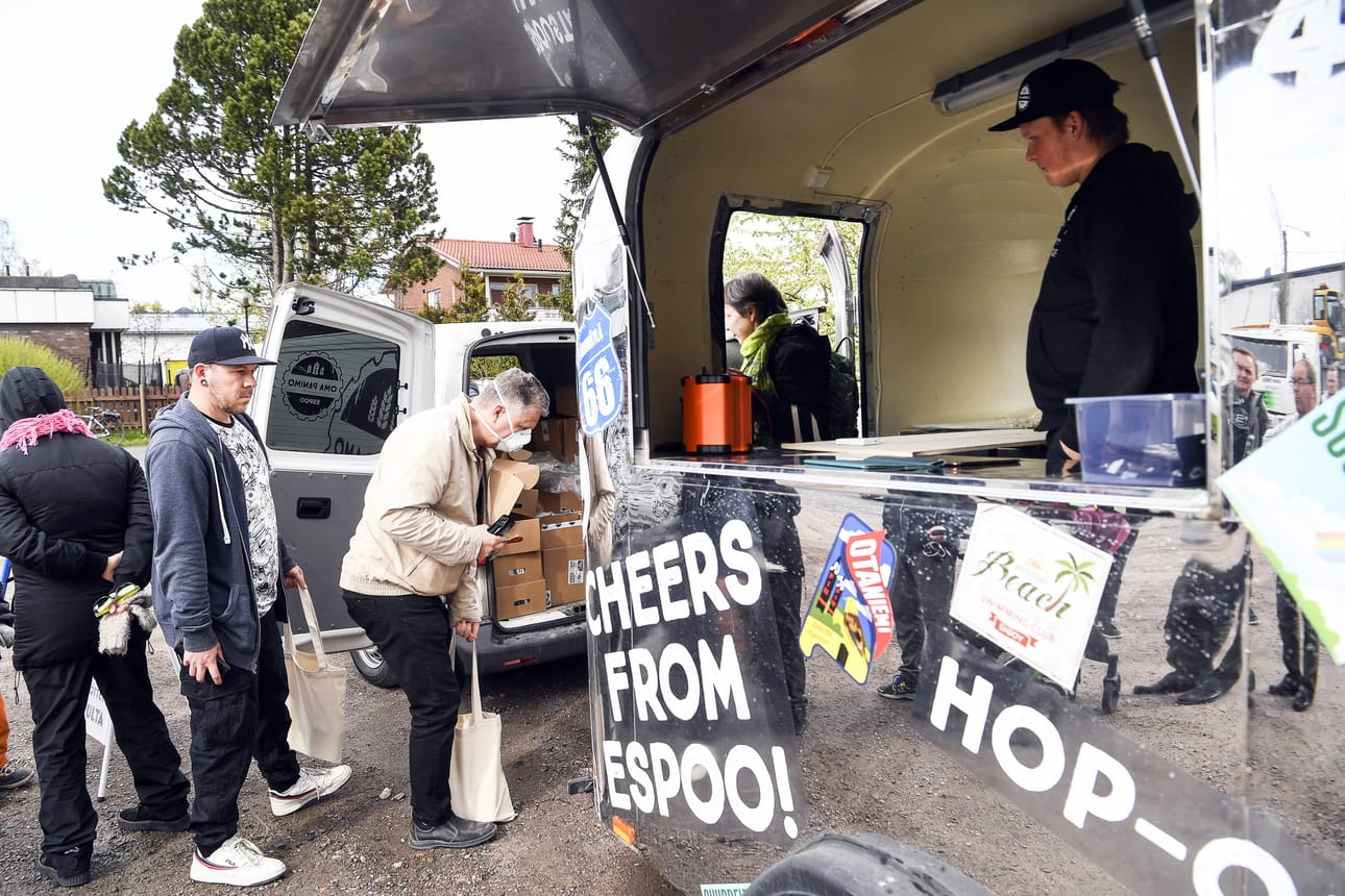 People queue in front of a mobile trailer selling local beer in Espoo. The Oma Panimo microbrewery came up with a new way to boost beer sales during the lockdown.