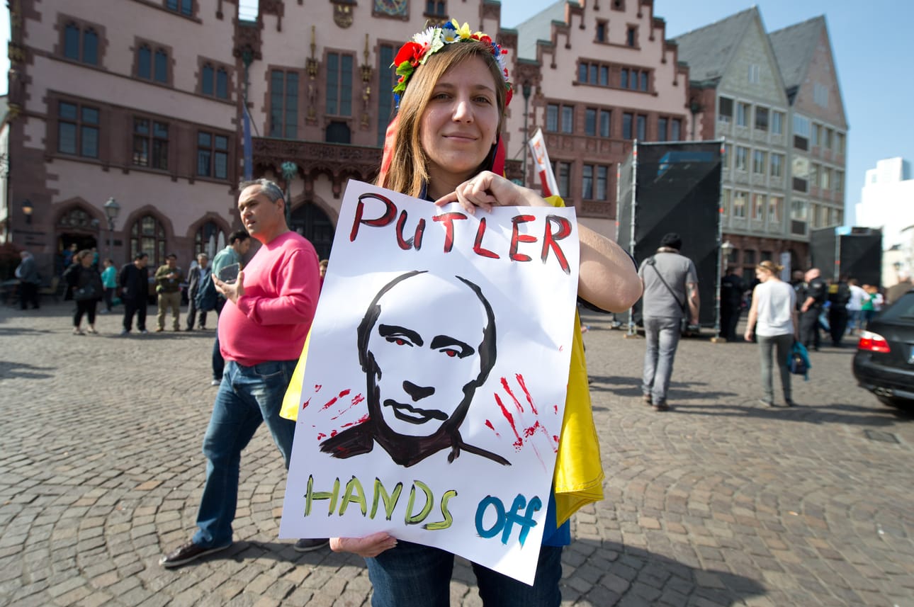 Putler-termiä ovat käyttäneet mielenosoittajat niin Venäjällä kuin Ukrainassa ja muualla Euroopassakin. Nimitystä ei voi pitää mairittelevana. Kuvan nainen vaati Putlerin näppejä irti Ukrainasta Saksan Frankfurtissa 30. maaliskuuta 2014. Poliisi suojasi mielenosoittajaa Putin-mielisten vastaprotestilta.