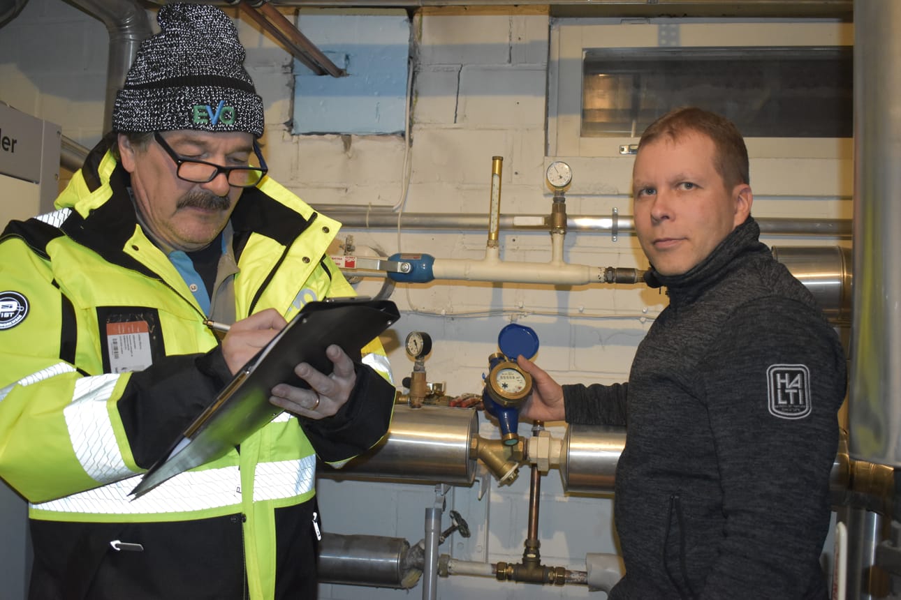 Jukka Mursu merkitsee ylös vanhan mittarin lukeman, jonka Sami Moilanen hänelle luettelee.