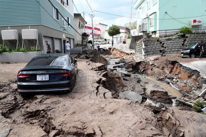 Auto hautautui mutaan maanjäristyksen runtelemalla kadulla torstaina Sapporossa, Hokkaidon suuurimmassa kaupungissa Japanissa. KUVA: JIJI PRESS