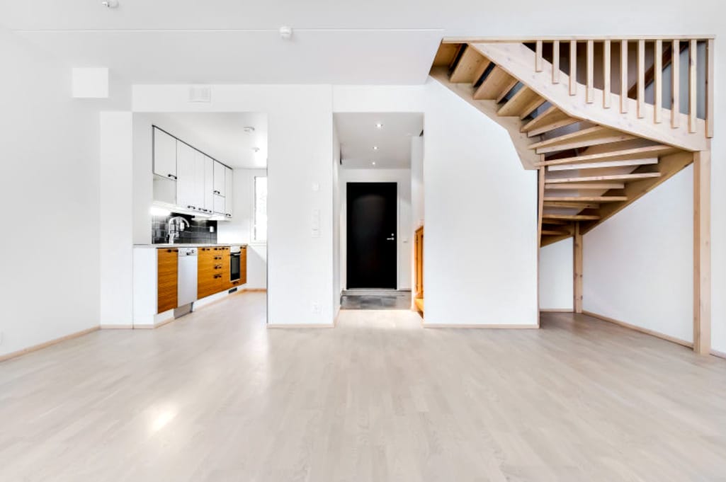 Avonaiset, seinäkkeen ympäri kiertävät portaat ovat olohuoneen persoonallinen yksityiskohta ja niiden alusta tarjoaa esimerkiksi piilopaikan lasten leikkeihin.