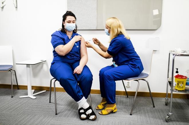 Sairaanhoitaja Piia Nuolikoski ei jännittänyt rokotetta, mutta hieman sitä, että ensimmäisestä rokotuksesta tuli niin julkinen. Rokotuskoordinaattori Satu Toivola antoi annoksen. KUVAT: KRISTA LUOMA