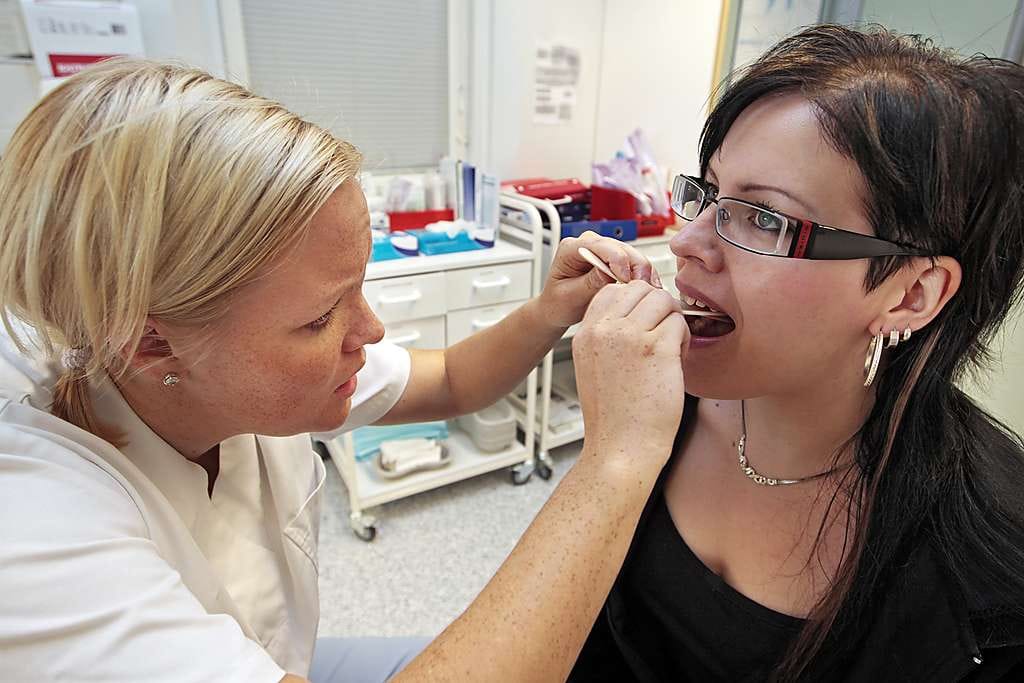 Terveydenhoitaja Riitta Pääaho ottaa nieluviljelyä Päivi Horsmalta Oulun Höyhtyän terveysasemalla. "Ohjaan potilaan angiinaepäilyn takia lääkärin vastaanotolle", Pääaho sanoo. Jos kurkusta löytyy A-streptokokki, potilas saa lääkekuurin.