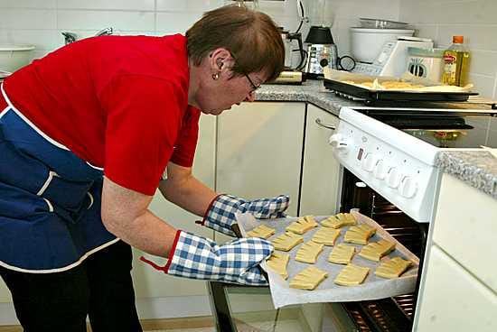 Elvi Seppänen paistaa kampanisuja 250-asteisessa uunissa noin kymmenen minuuttia.