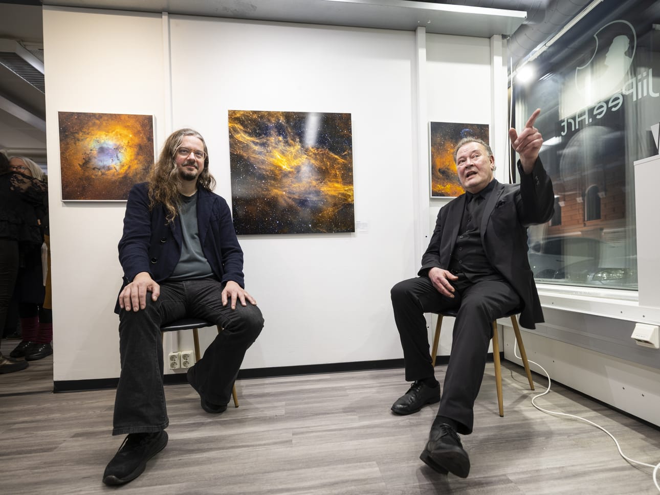 Oululainen astrokuvaaja Jukka-Pekka Metsävainio (oik.) kertoi säveltäjä Lauri Porralle ja galleriayleisölle, että avaruuskuvat tallentavat vanhaa valoa ja ne maalataan ajalla. Prosessit ovat valtavan hitaita. Kuvat ovat totta, niitä ei muokata.