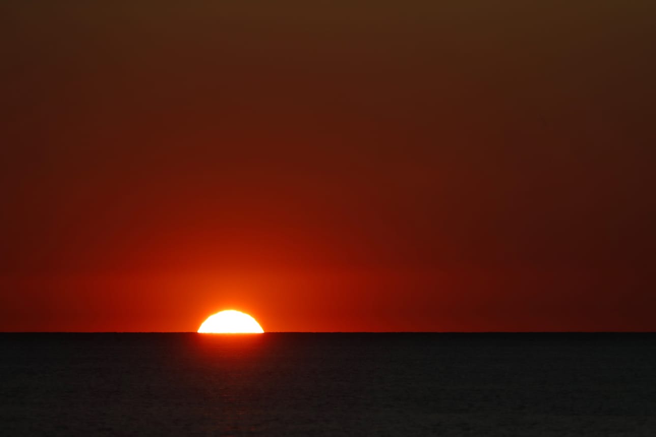 Aurinko ehtii laskea maan etelä- ja itäosissa ennen pimennyksen päättymistä. Kuvituskuva.