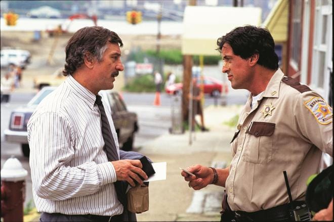 Sylvester Stallone (oik.) on Cop Land -jännityselokuvassa Freddy Heflin, joka alkaa selvittää rikosta. Osallisena on poliisi. Robert De Niro on sisäisen tutkinnan etsivä Moe Tilden, joka selvittää samaa rikosta. KUVA: Yle Kuvapalvelu