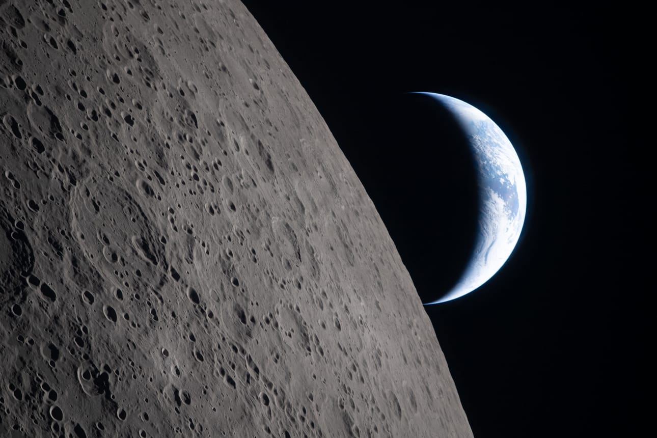 Astronautit kuvasivat 6. huhtikuuta Orion-alukseltaan Kuuta ja Maata. Maapallo näkyy Kuun takaa sirppinä. Mustassa osassa maapalloa eletään yötä. Australiassa ja Oseniassa on valoisa päivä.