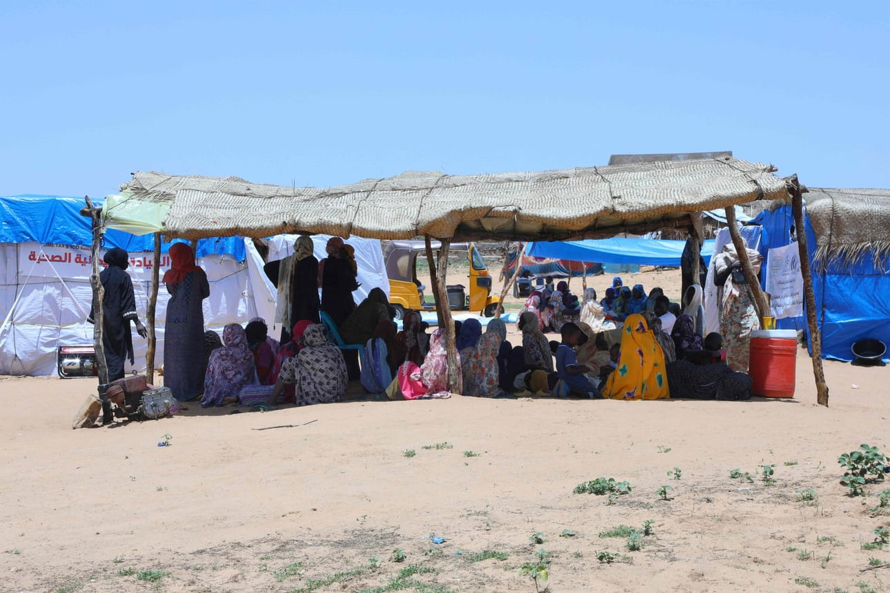 Levottomuuksia paenneita sudanilaisia on pakolaisleireillä myös Sudanin ulkopuolella. Kuvassa ihmiset odottavat terveydenhuoltoa Tshadin itäosassa lähellä Sudanin rajaa. LEHTIKUVA/AFP