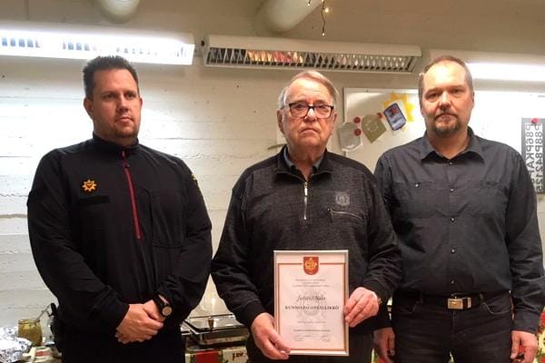 Jarkko Aho ja Miko Mäkelä luovuttivat Juhani Salolle kunniapalopäällikön kunniakirjan. KUVA: JARMO NURMELA