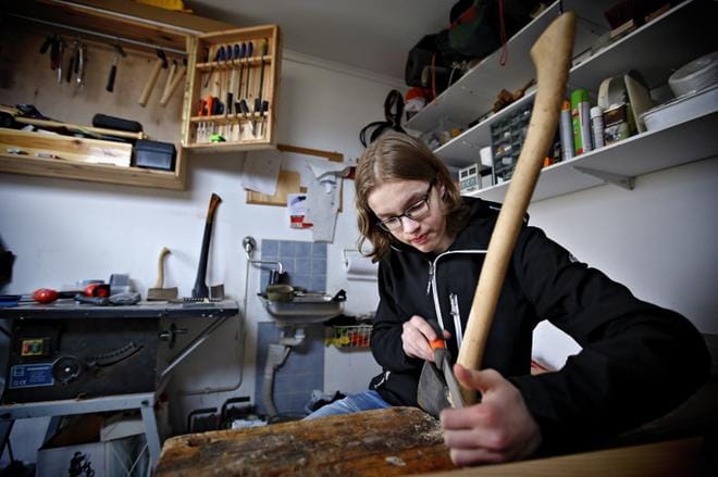 Nurmolainen nuori käsityöihme Mikael Peltoketo palkittiin tänään Seinäjoella nuorena käsityöntaitajana. Kuvassa hän korjailee ja viimeistelee kotiverstaassaan itse tekemäänsä kirveen kahvaa, josta hän viilaa vaurioituneen puun pois. Kuva: Tomi Kosonen