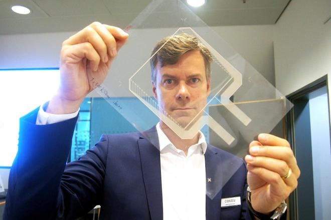 Suomessa kehitetty ja valmistettava nanohiilikalvo on täysin läpinäkyvää, sähköä hyvin johtavaa, kevyttä ja venyvää materiaalia. Kalvoon voidaan integroida tarvittavat kosketuksen aistivat anturit ja sensorit, toimitusjohtaja Juha Kokkonen näyttää. Kuva: Kari Pitkänen