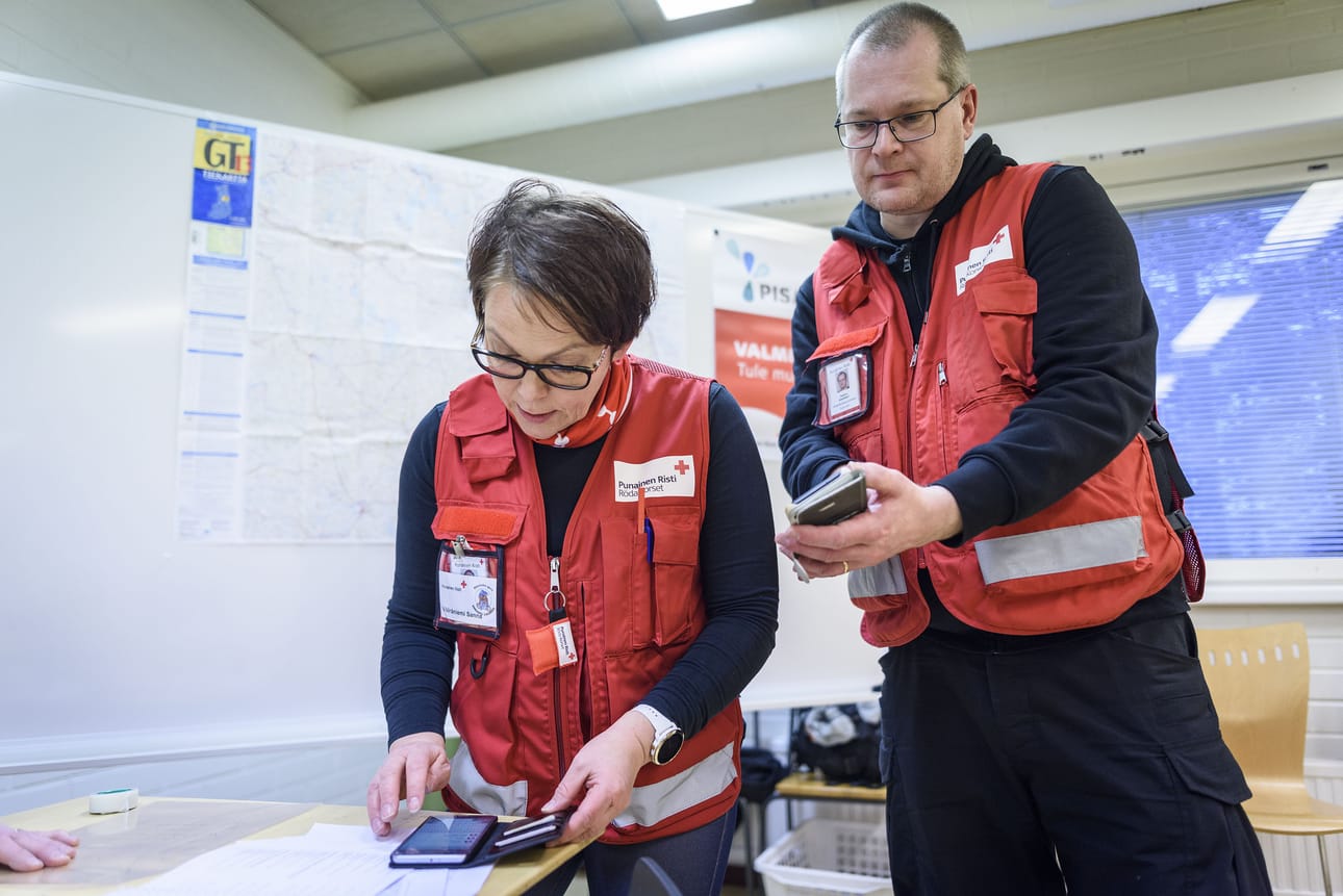 Johtokeskuksen johtaja Sanna Vääräniemi käy harjoituksessa läpi Teemu Alapeterin kanssa SPR:n ja viranomaisten käyttämän OHTO-viestintäjärjestelmän käyttöä. Sillä viestitään nyt Taivalkosken vapaaehtoisille ja kartoitetaan missä ajassa lisäkäsiä saadaan avuksi muun muassa vedenjakeluun.