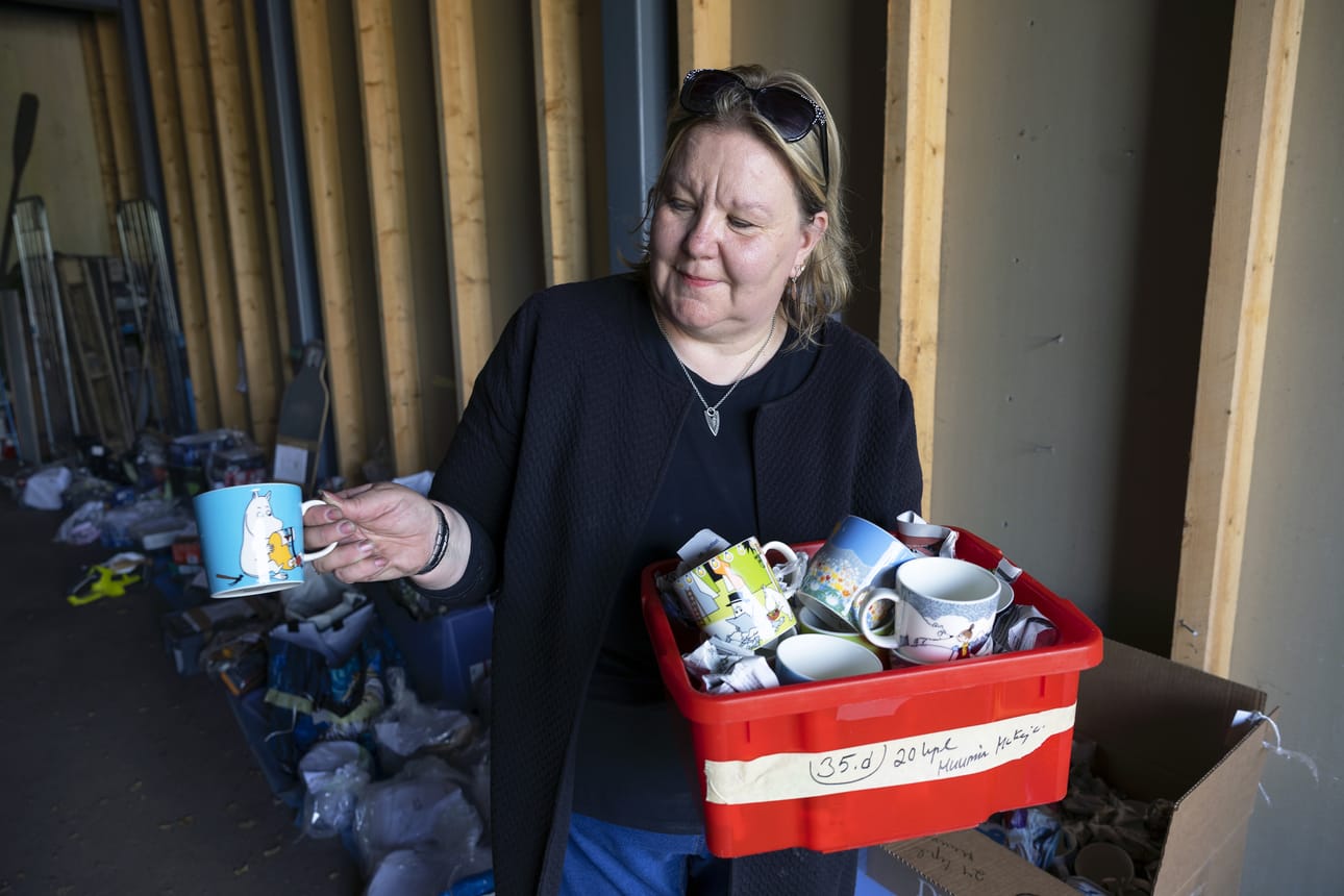 Ann-Louise Olén esittelee myyntiin pistettäviä muumimukeja.
