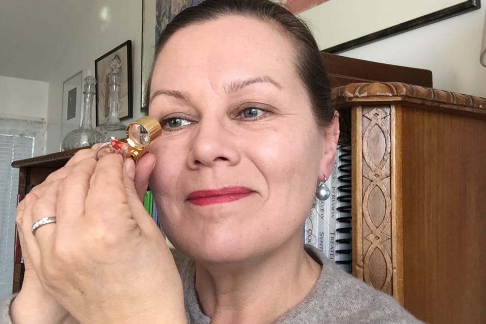 Ilse Gröndahl-Ahlqvist tutkii luupilla sormuksen kiveä. Kauniit jalokivet ja myös luonnonkivet saavat hänet innostumaan aina uudestaan.
