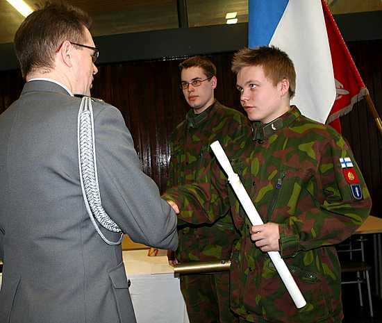 Rykmentin komentaja everstiluutnantti Hannu Kylmäniemi onnittelemassa parhaana sotilaspoliisina palkittua korpraali Olli Hemminkiä. Vuoroaan odottaa tykkimies Esa Kauranen.