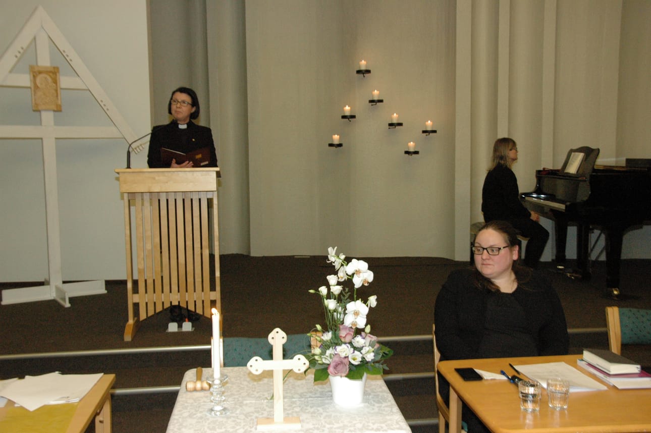 Ennen kirkkovaltuuston kokousta pidettiin muistohetki kirkkoherra Taina Mannisen johdolla. Edessä valtuuston uusi puheenjohtaja Elina Kemppainen ja taustalla kanttori Maria Suviaro.