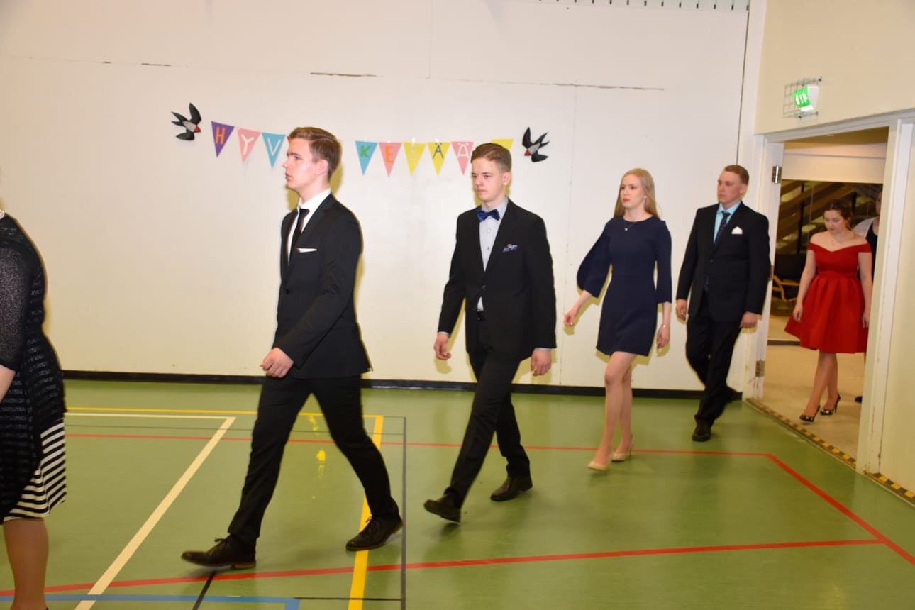 Ylioppilaat marssivat saliin kauniissa asuissaan.