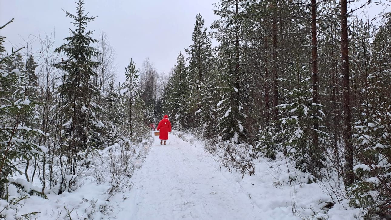 Joulupukki tallusteli polulla jakaen karkkeja.