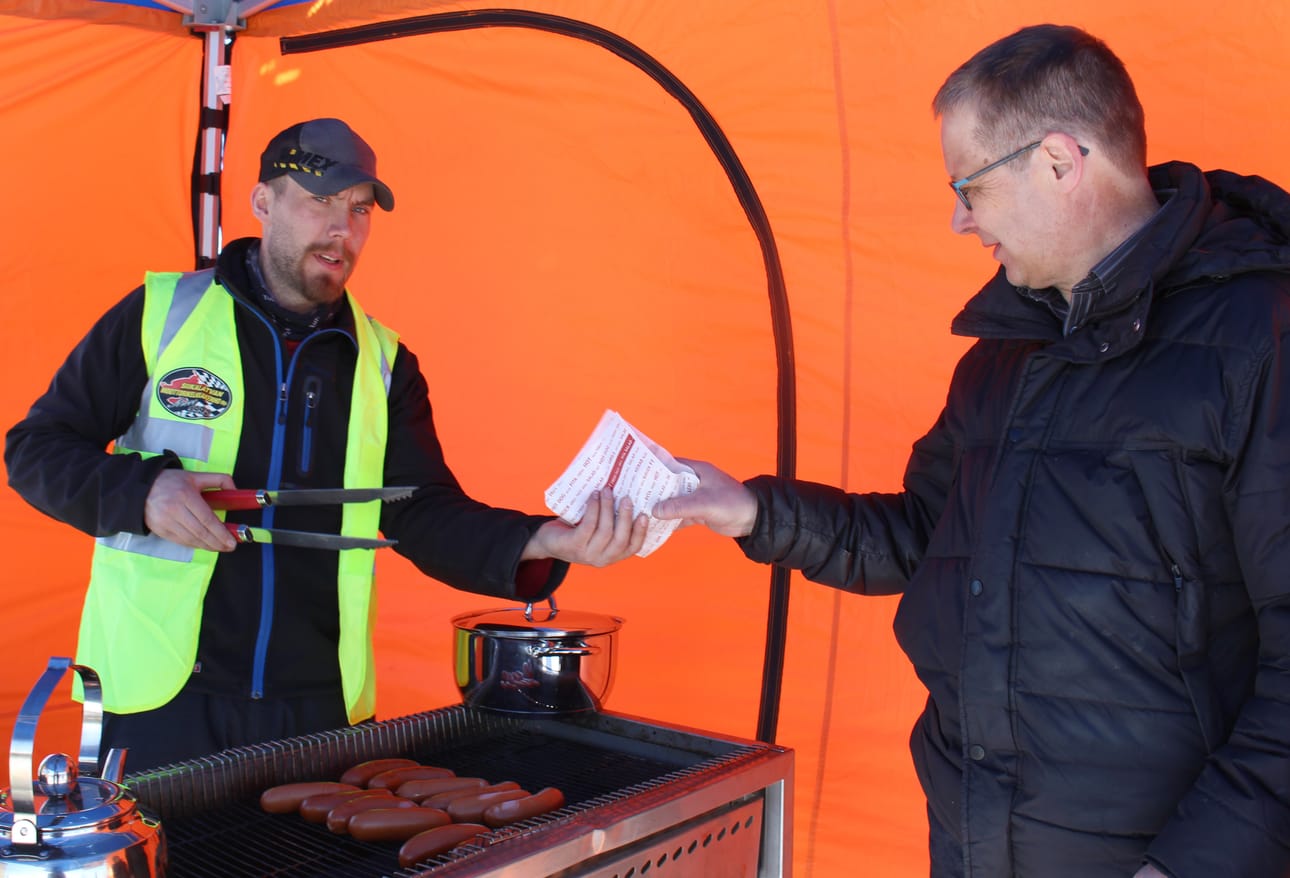 Siikalatvan Moottorikelkkakerhon uusi puheenjohtaja Jarkko Väyrynen oli vastuutettu makkaran myyntiin Orsiniemen Snowcross-radan avajaistapahtumassa. Makkarakojulla ostoksilla Timo Aitto-oja.