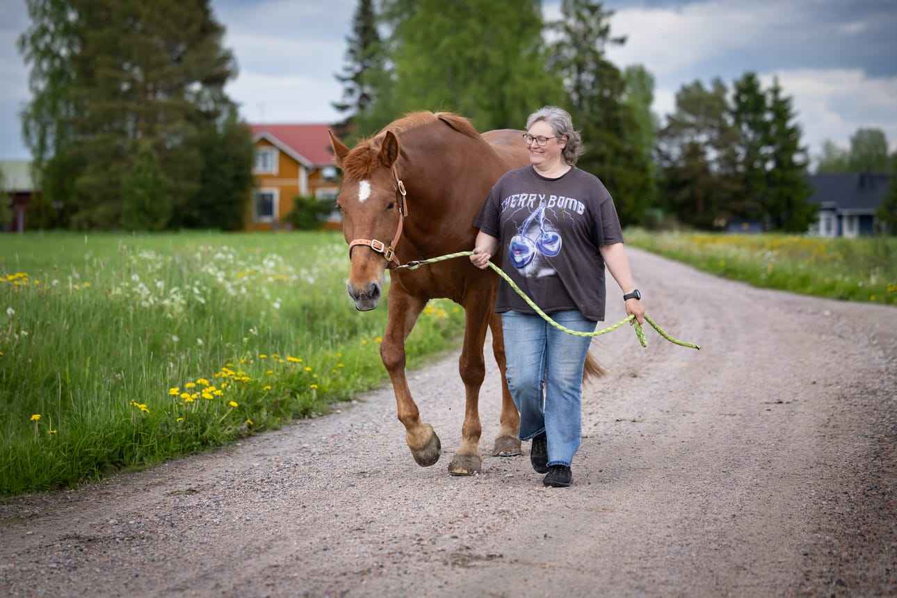 Suomenhevostamma Henkan Juulia askeltaa Annika Pukkisen vierellä reippaasti.