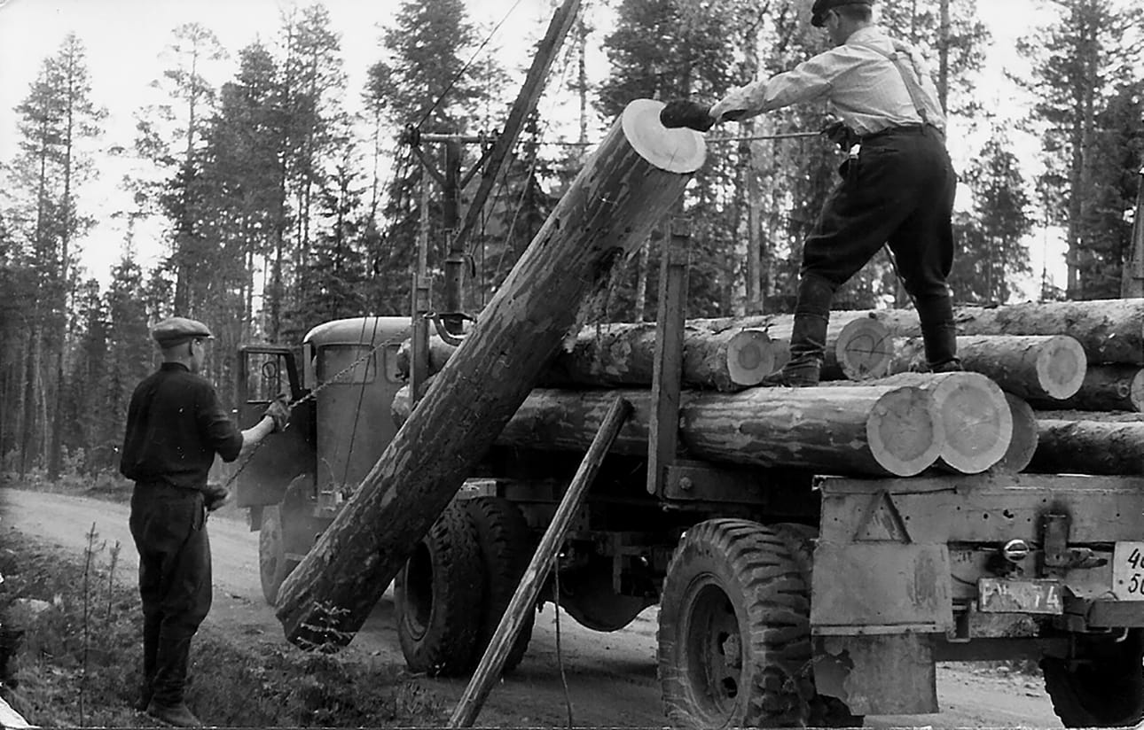 Tukin kuormausta 1956. Kuvassa sama auto tukinkuormausvarusteissa, jolla tarinan Kokkolareissu tehtiin. Kuljettaja Toivo Kervinen on narupoikana ja Raimo Kinnusen isä Viljo kuorman päällä.