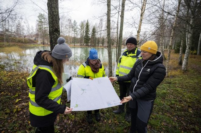 Hanna-Leena Ventin, Leena Roininen, Jarmo Latvala ja Suvi Aho esittelevät karttaa, johon on merkitty esimerkiksi Kirkkolammen lasketusaltaiden paikat. KUVAT: JARNO PELLINEN