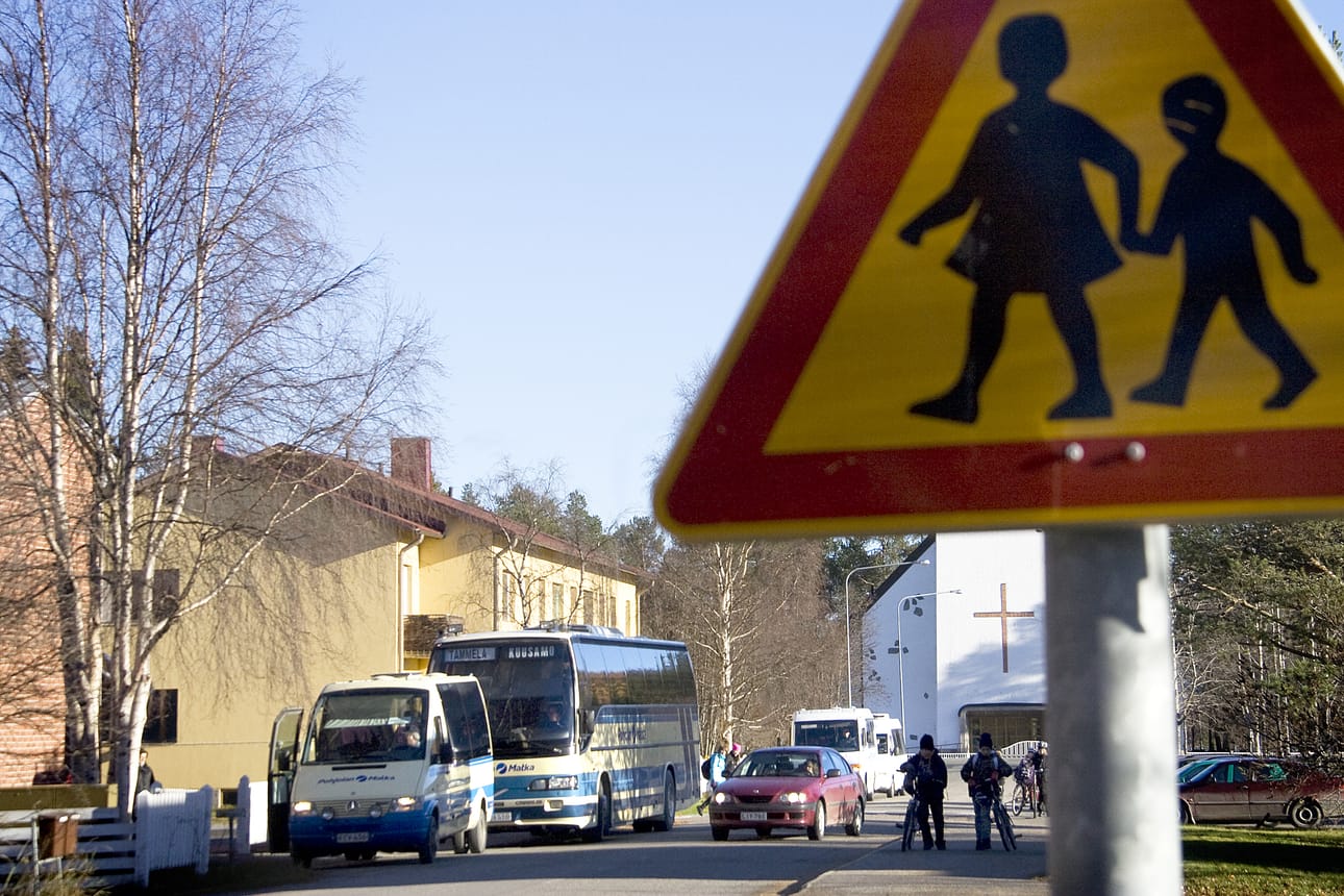 Kuusi linja-autoa jonottaa kadunlaidassa samalle pysäkille Kirkkotiellä Kirkkokedon koulun kohdalla Kuusamon seurakuntatalon edessä.
