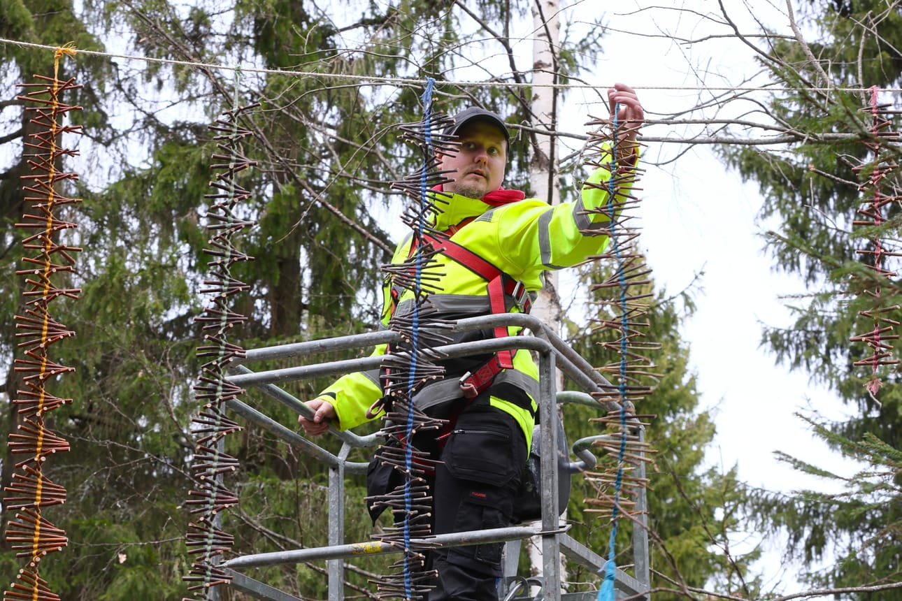 Luontopajan väkeä oli mukana nostamassa taideteoksia korkeuksiin. Hyrriä paikalleen laittaa Joni Kopsala.