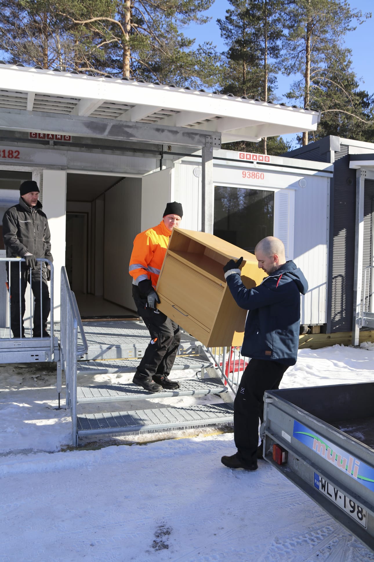 Marko Uusitalo, Markku Vanha ja Toni Rautasuo kantoivat puhdistettuja kalusteita kunnantalon pihaan pystyttettyyn parakkitoimistoon.