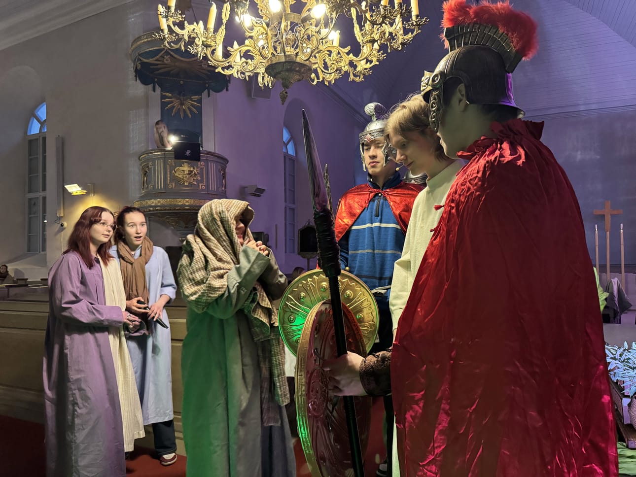 Via Dolorosa kärsimysnäytelmässä opetuslapset Nita Leinonen ja Martta Rahkala katsovat, kun Juudas Lotta Mäkiranta paljastaa Jeesus Eemeli Perkkiön sotilaille Juho Hammarille ja Jaakko Iivarille. Näyttämönä oli Alatornion kirkko.